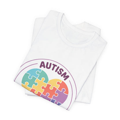 t-shirt with a colorful heart puzzle design and 'Autism Different Not Less' text on a white background