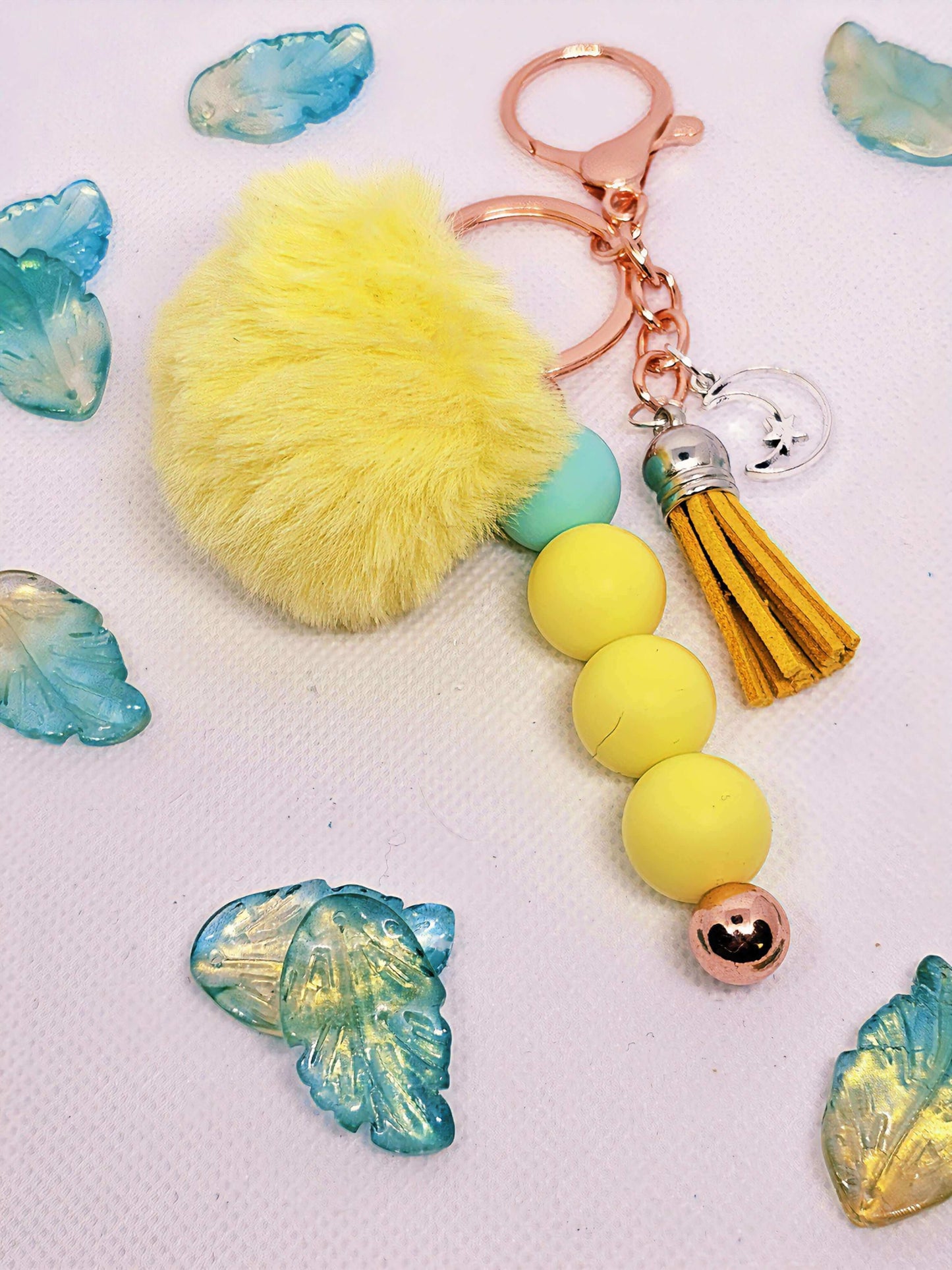 A yellow and Teal puff handmade keychain with moon charm, handmade designs